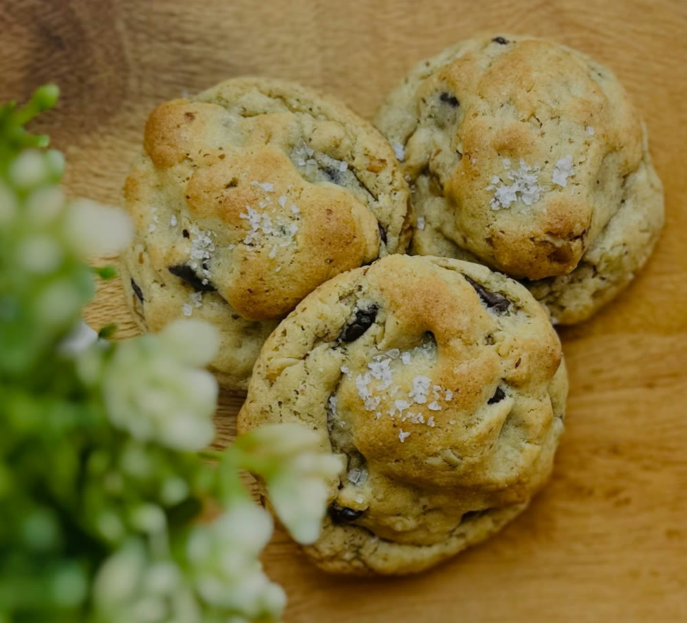 Sea-salted chocolate chip cookies on a wooden board