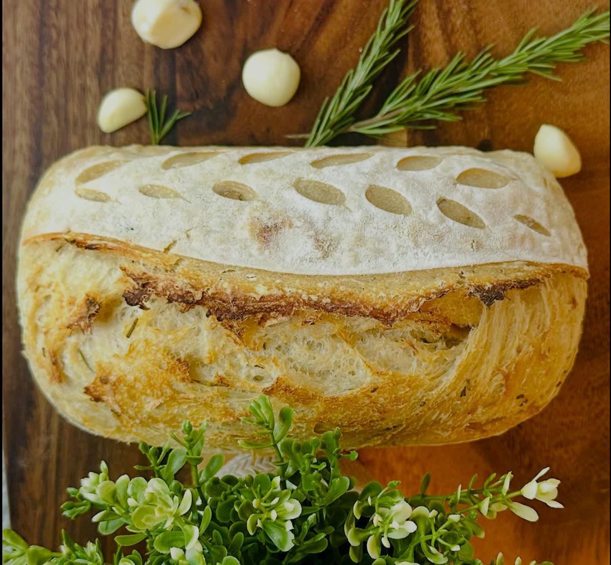 A roasted garlic and rosemary loaf, scored and split open